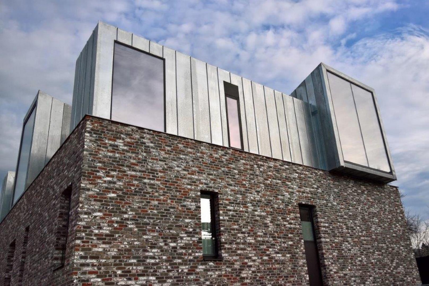 Een moderne woning met donkere steenstrips als gevelbekleding.