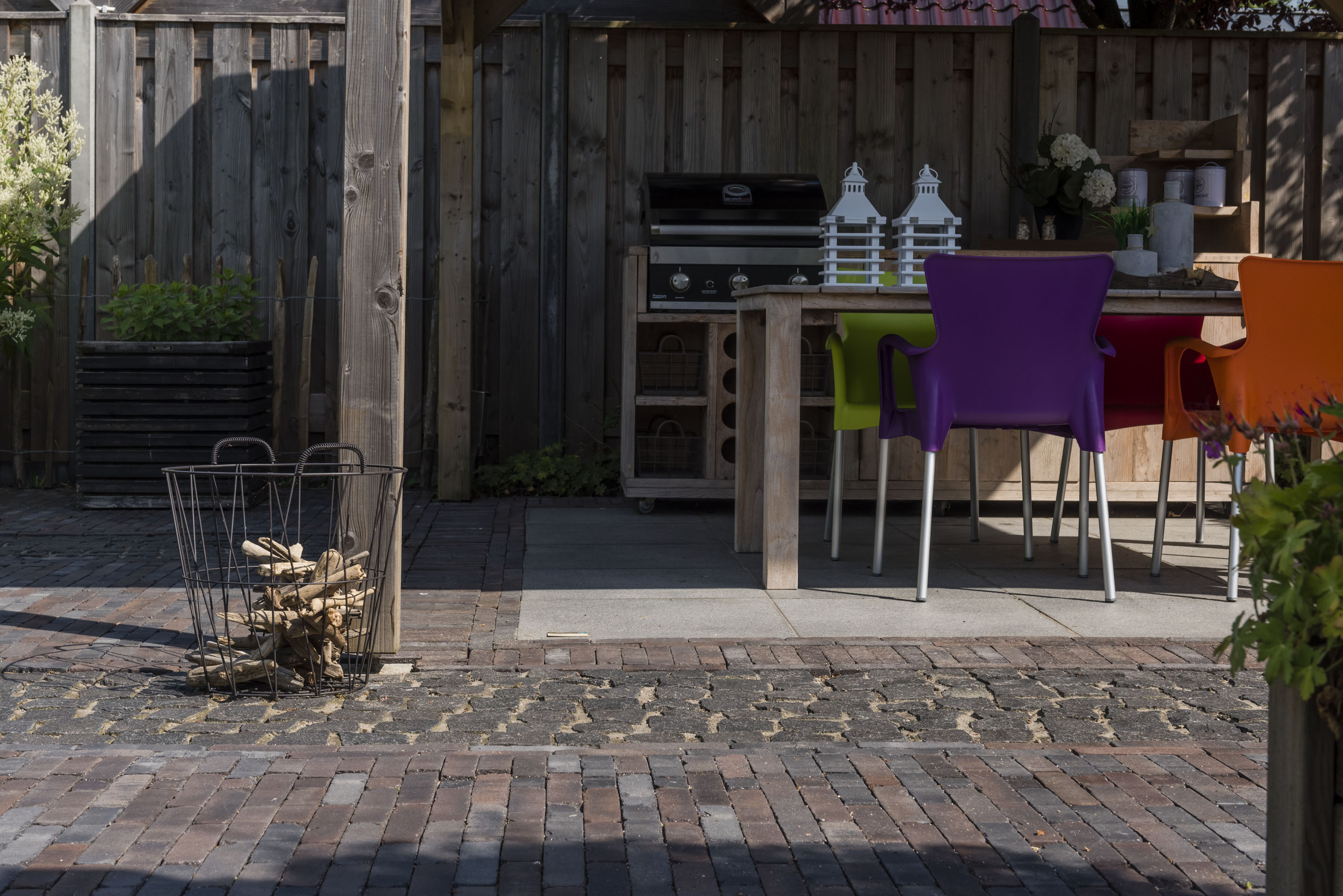 Een terras met buitenkeuken en verschillende soorten klinkers.