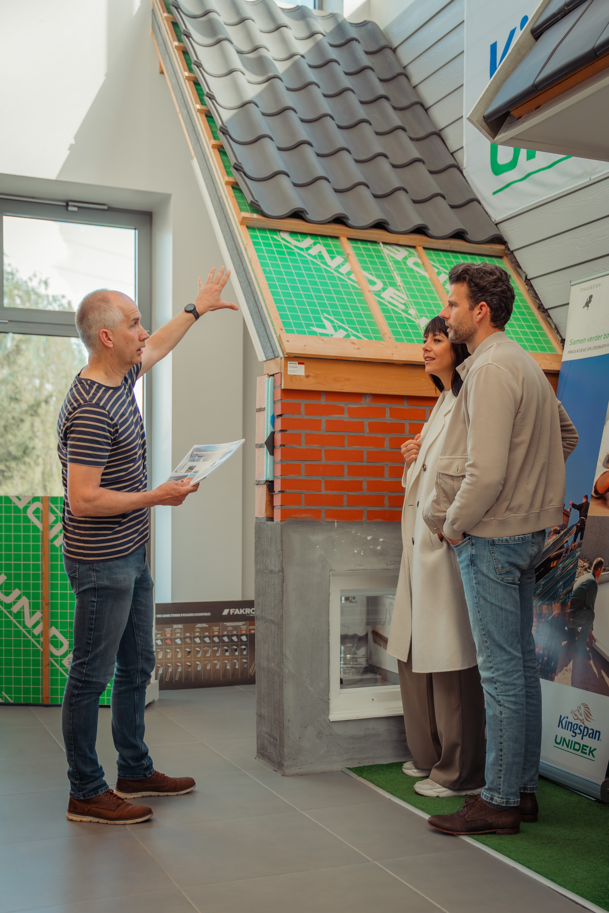 Medewerker van Wijckmans geeft informatie over dakisolatie aan klanten in hun showroom.